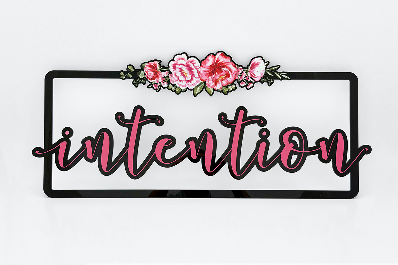 an image showing a black acrylic laser cut frame with white ink base and full color flowers and type 